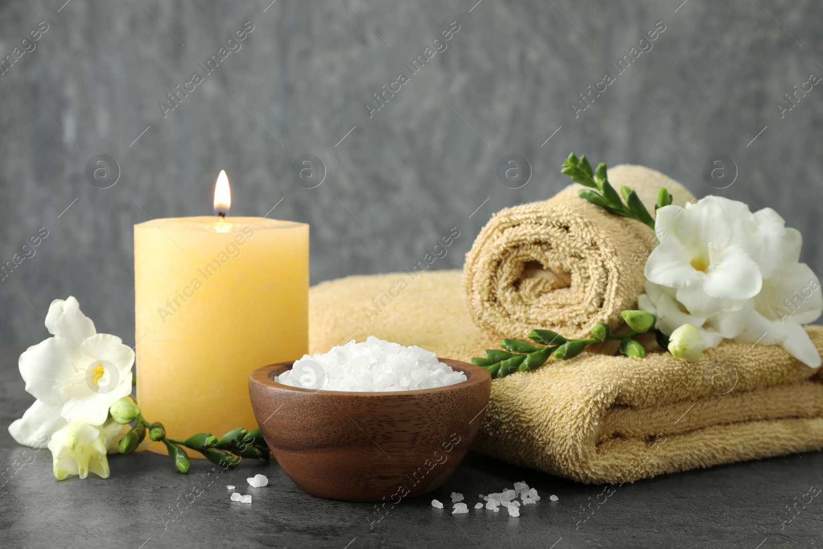 Photo of Composition with different spa products and burning candle on grey table