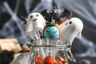 Different Halloween themed cake pops on blurred background, closeup