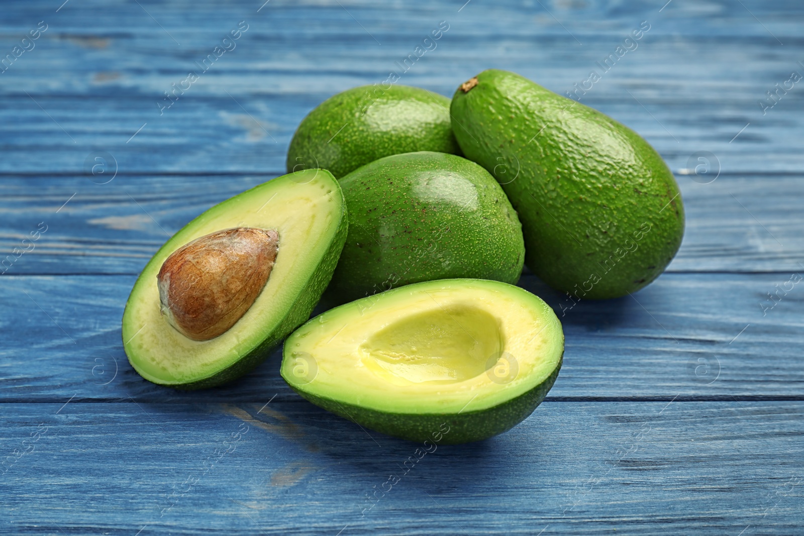 Photo of Tasty ripe green avocados on wooden background