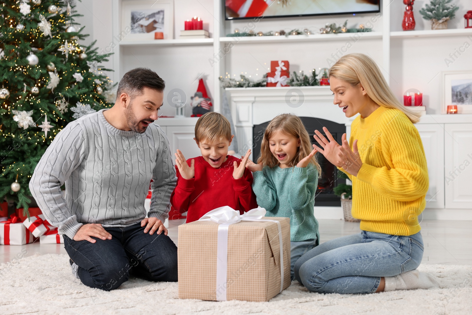Photo of Surprised family with Christmas gift at home
