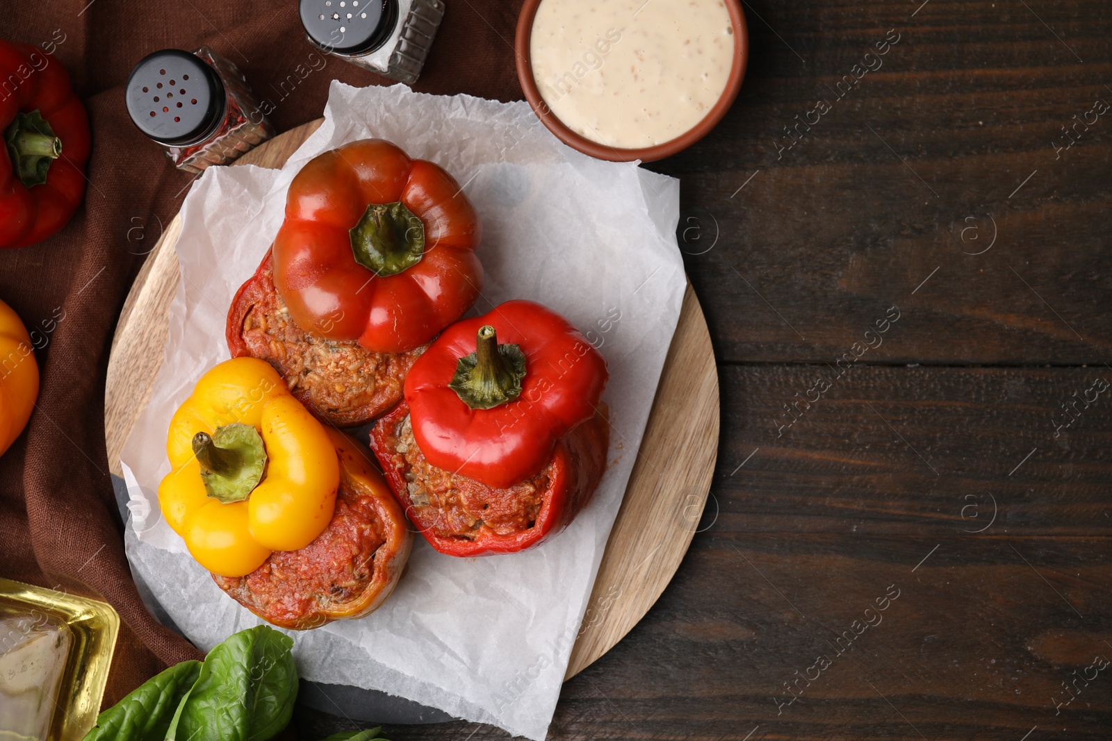 Photo of Delicious stuffed bell peppers served on wooden table, flat lay. Space for text