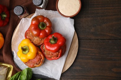 Photo of Delicious stuffed bell peppers served on wooden table, flat lay. Space for text