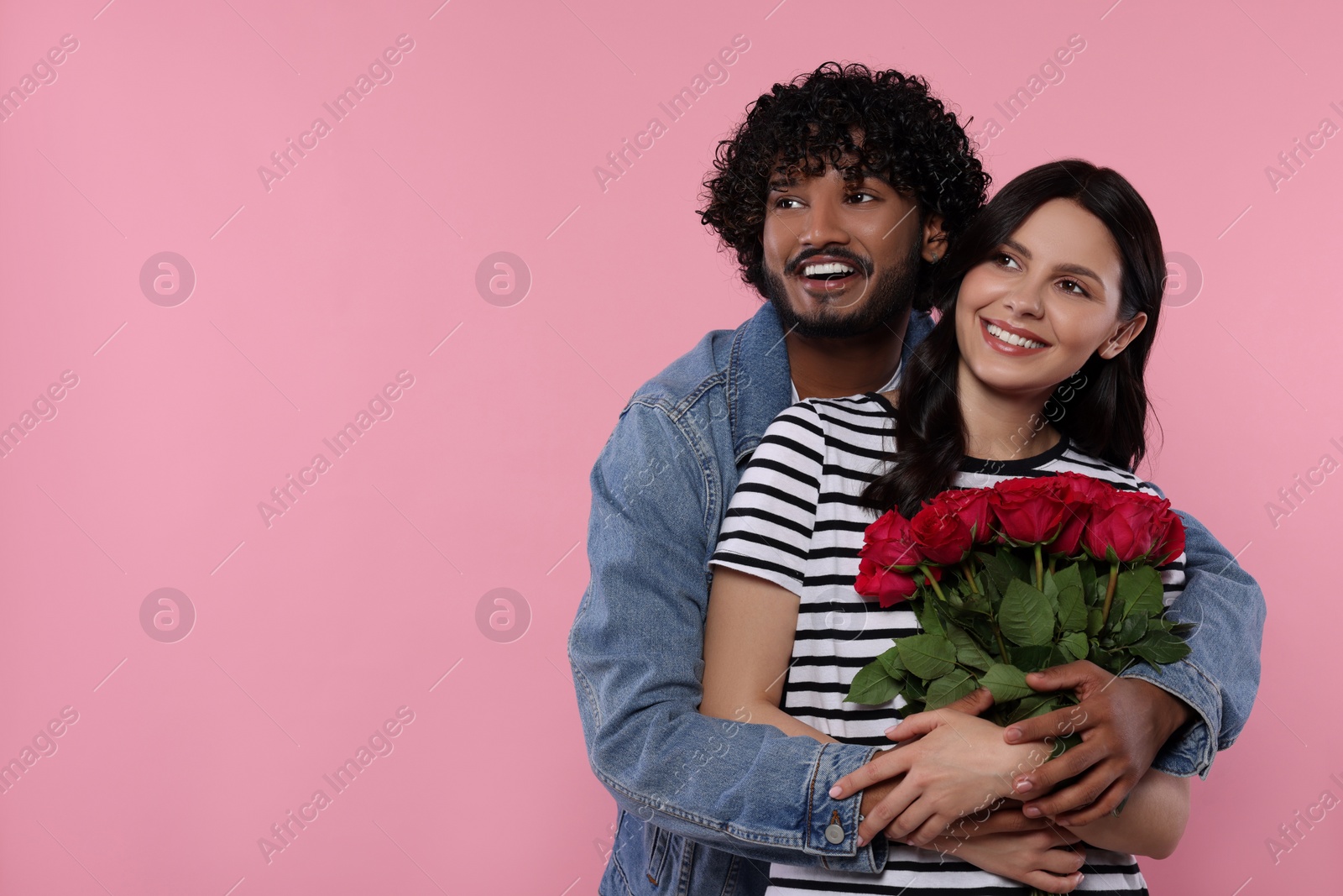 Photo of International dating. Happy couple with bouquet of roses on pink background, space for text