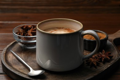 Photo of Cup of delicious eggnog with anise on wooden table