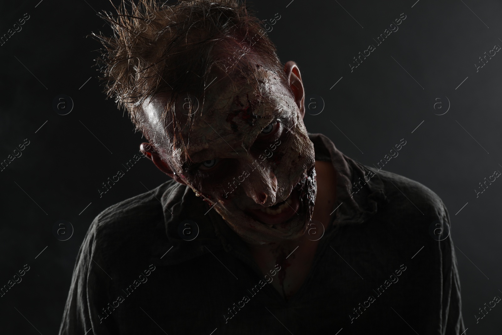 Photo of Scary zombie on dark background. Halloween monster