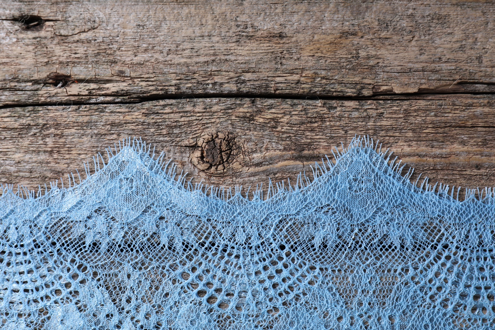 Photo of Beautiful lace on wooden table, top view. Space for text