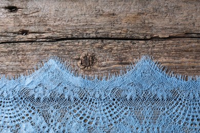 Beautiful lace on wooden table, top view. Space for text