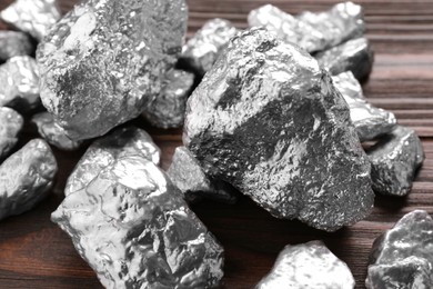 Photo of Pile of silver nuggets on wooden table, closeup