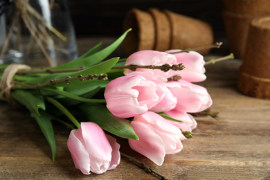 Photo of Beautiful bouquet of spring pink tulips on wooden table, closeup