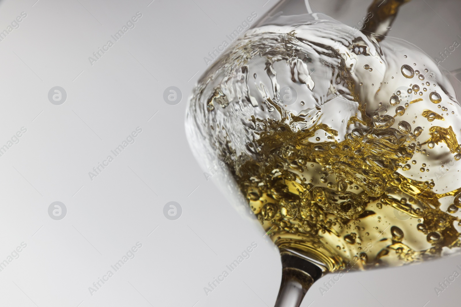 Photo of Tasty aromatic wine in glass on gray background, closeup. Space for text