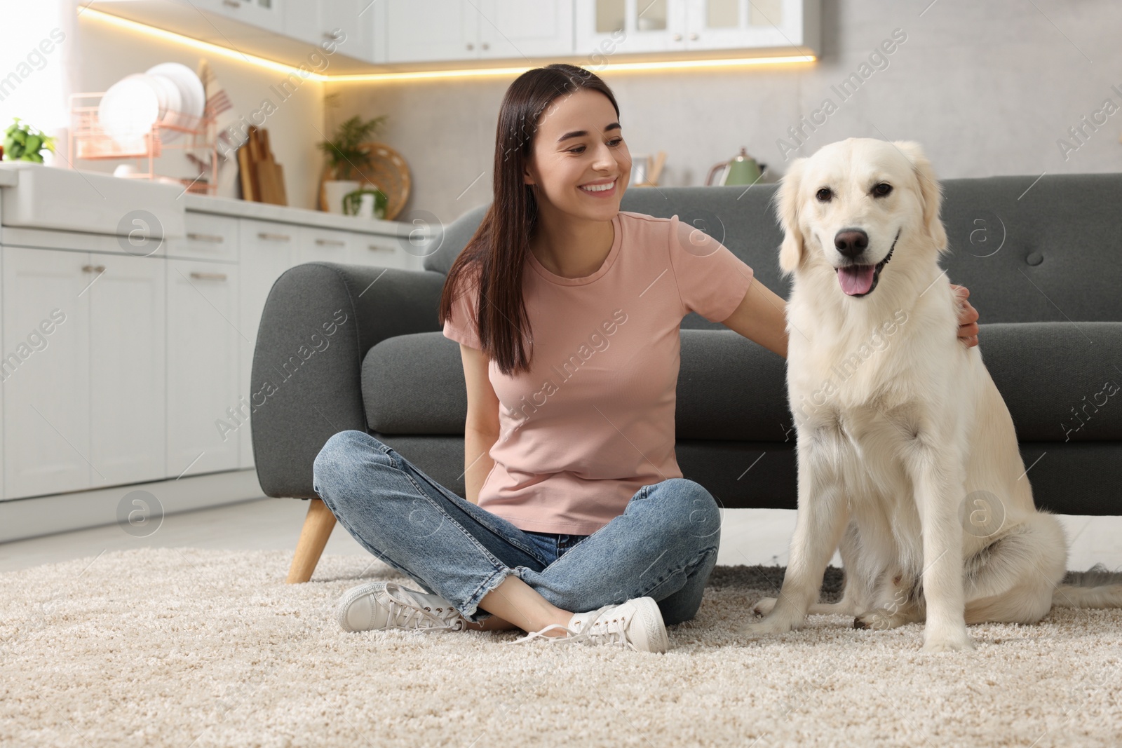 Photo of Happy woman with cute Labrador Retriever dog on floor at home. Adorable pet