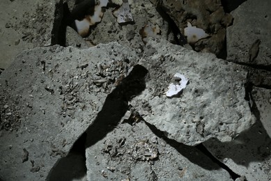 Pieces of concrete and burnt paper as background, top view