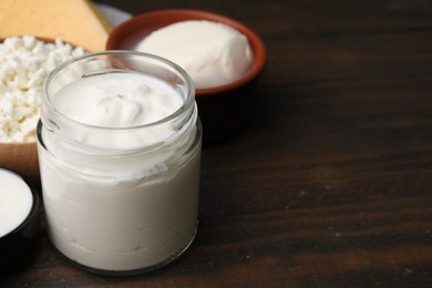 Photo of Different fresh dairy products on wooden table, space for text