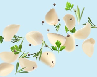 Image of Fresh peeled garlic cloves, peppercorns, parsley and rosemary flying on light blue background