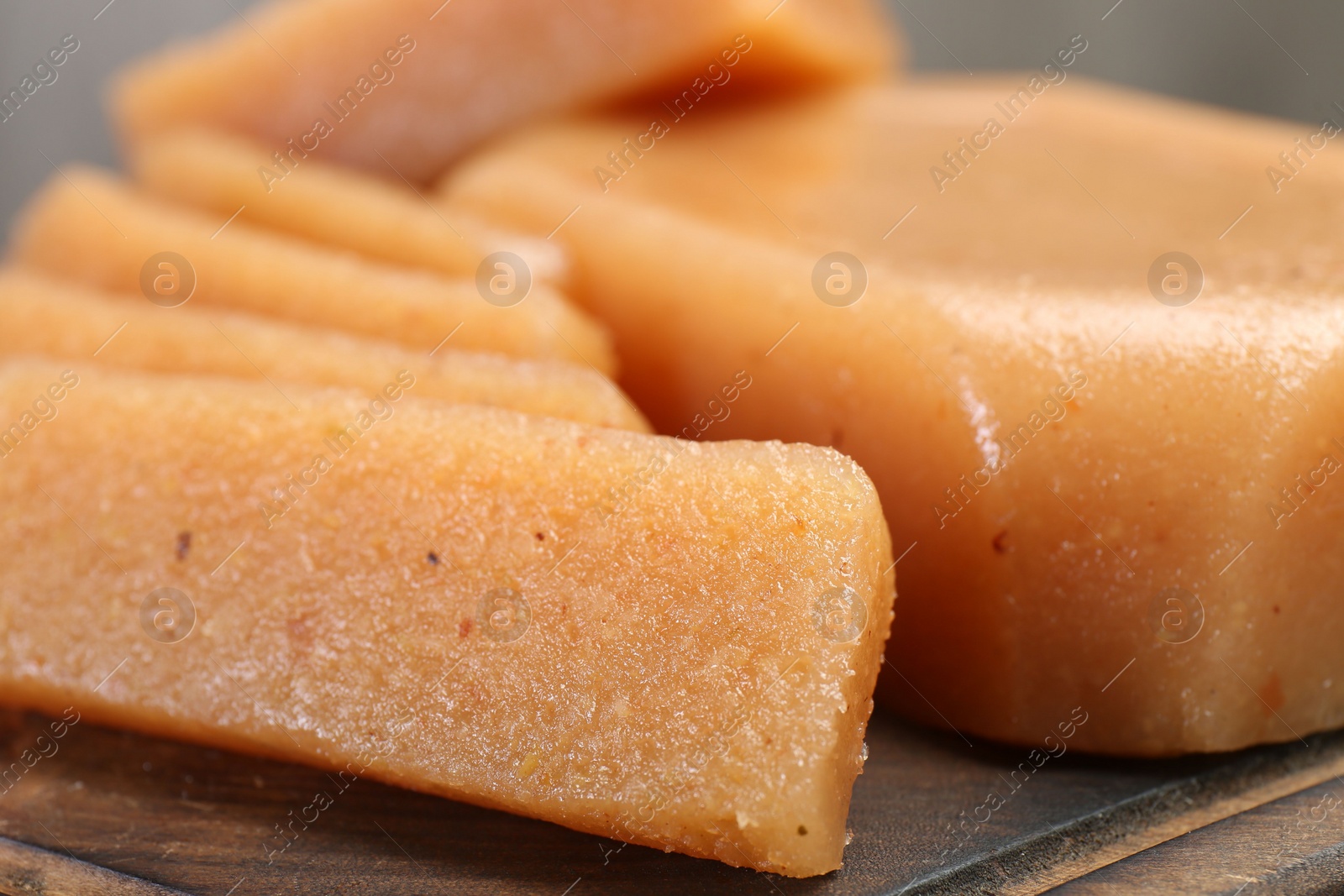 Photo of Tasty sweet quince paste on wooden board, closeup