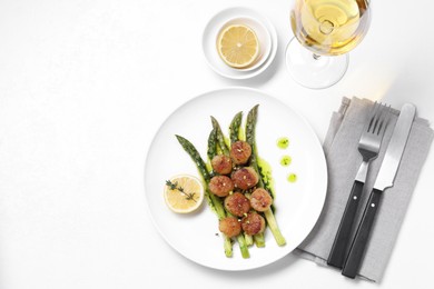 Photo of Delicious fried scallops with asparagus, lemon and thyme served on white table, flat lay. Space for text