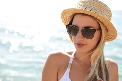 Photo of Beautiful woman wearing sunglasses near sea on sunny day