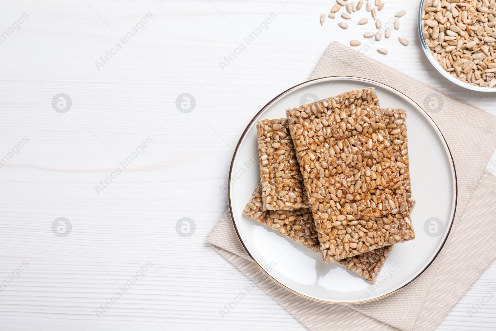 Photo of Delicious sweet kozinaki bars on white wooden table, flat lay. Space for text