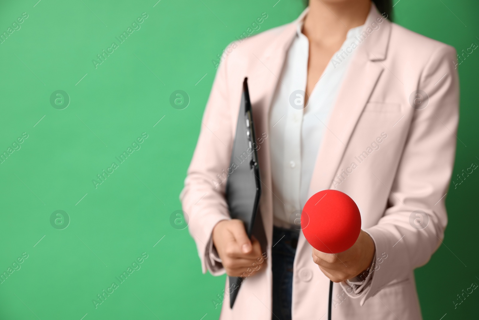 Photo of Journalist with microphone and clipboard on green background, closeup. Space for text