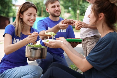 Photo of Poor people receiving food from volunteers outdoors