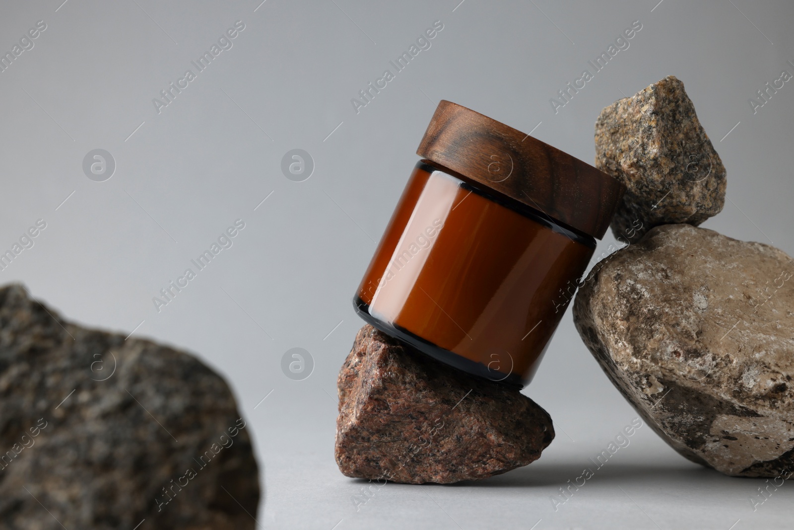 Photo of Glass jar and stones on grey background, closeup