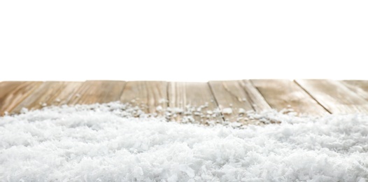 Heap of snow on wooden table against white background. Christmas season