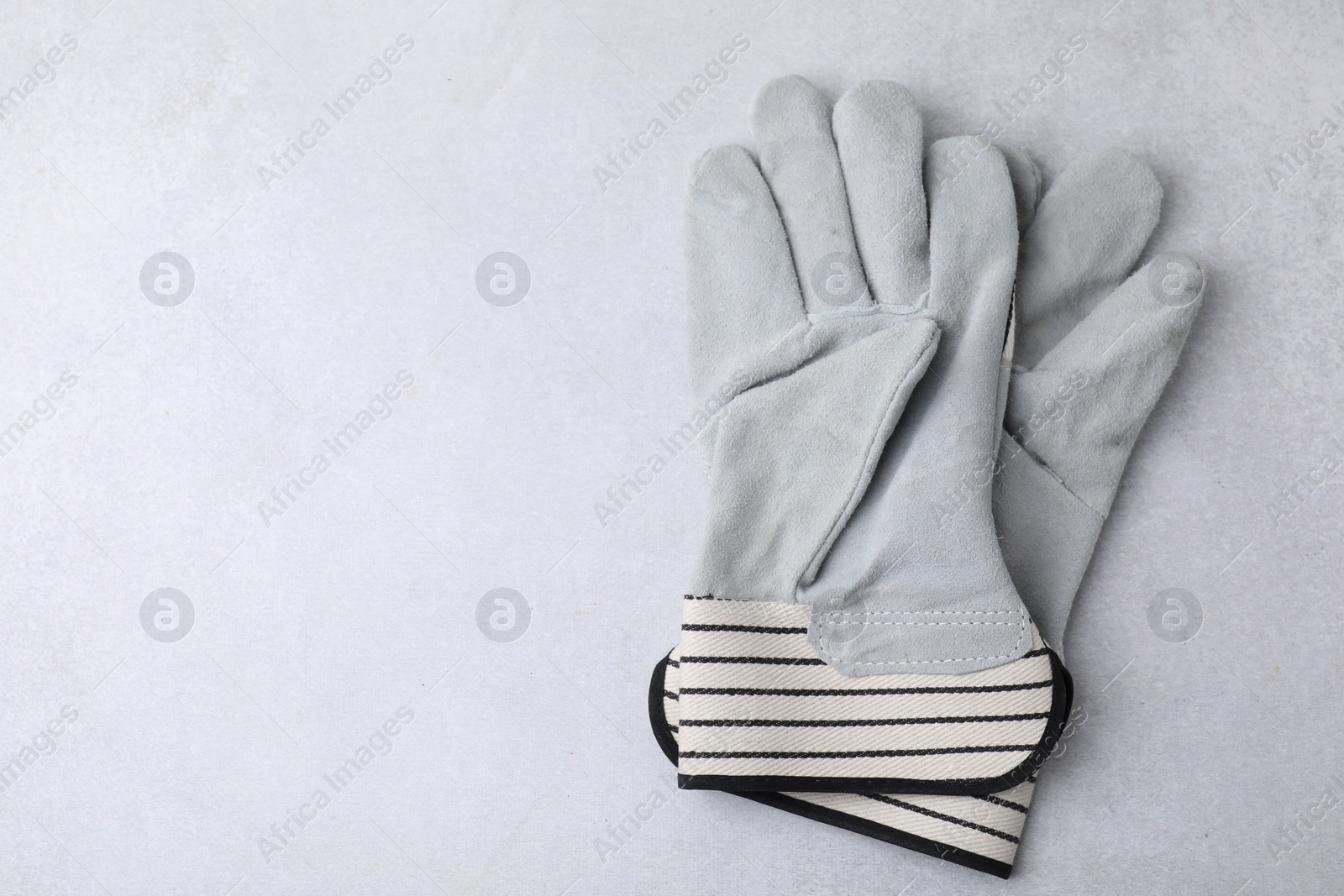 Photo of Pair of color gardening gloves on light grey table, above view. Space for text