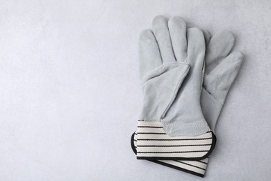 Photo of Pair of color gardening gloves on light grey table, above view. Space for text