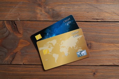 Photo of Two credit cards on wooden table, top view