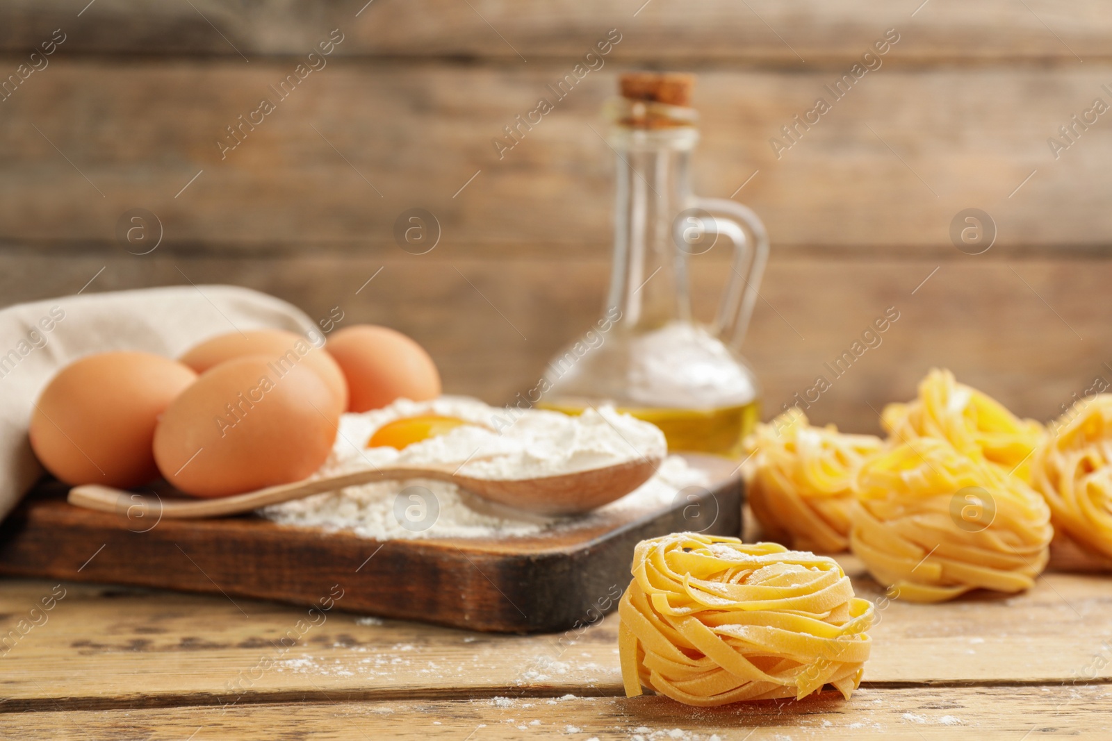 Photo of Raw noodles and ingredients on wooden table, space for text