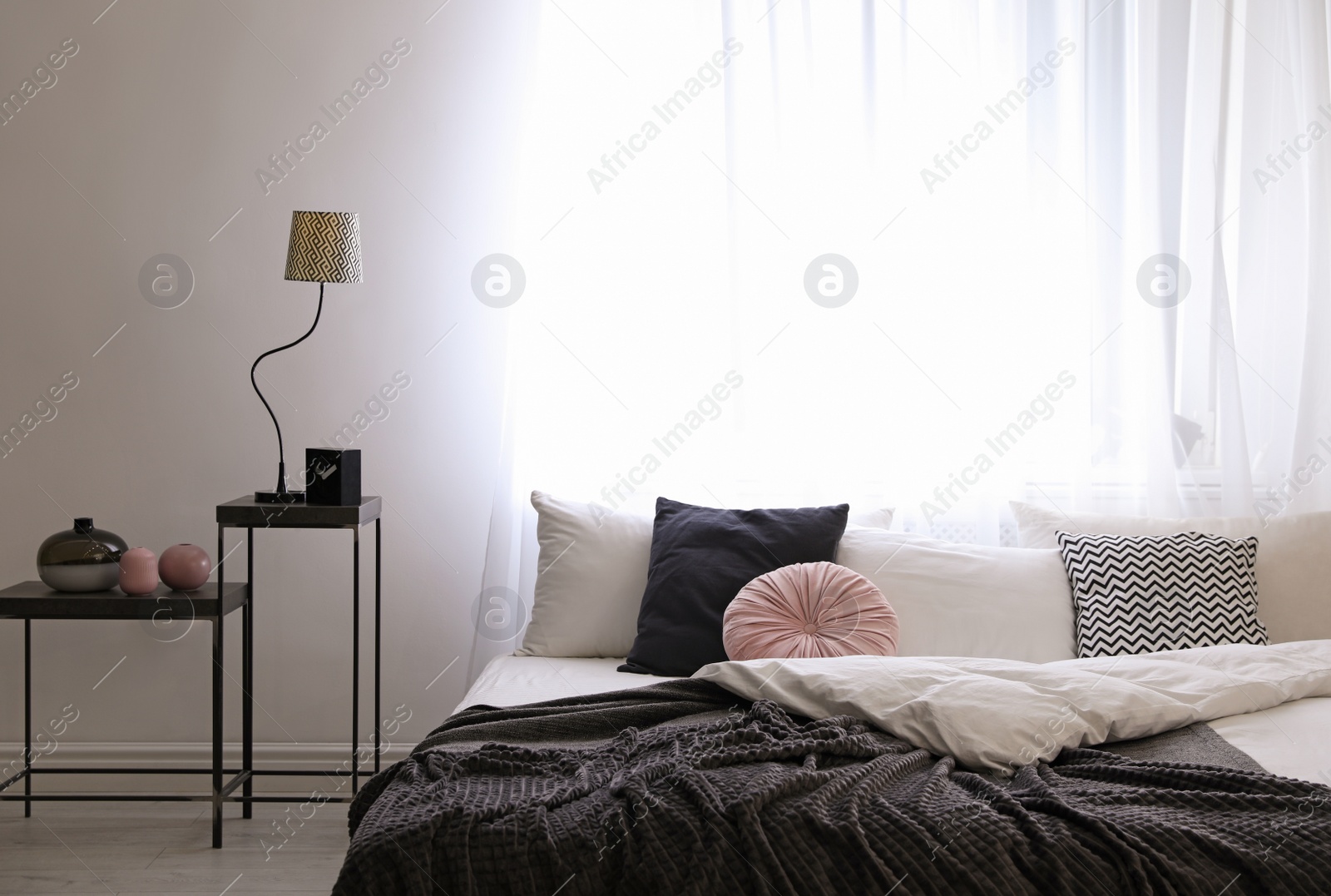 Photo of Large comfortable bed in stylish room interior