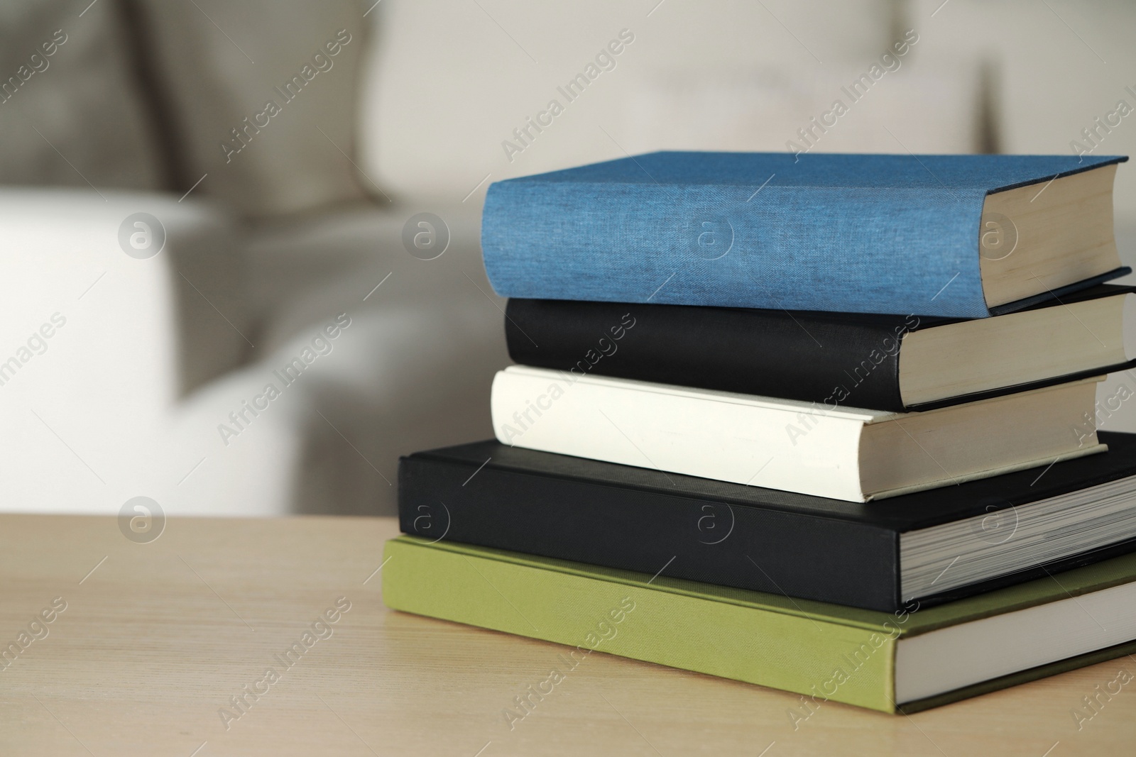 Photo of Stack of hardcover books on wooden table indoors, space for text