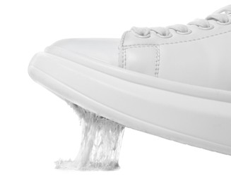 Shoe with chewing gum on sole against white background, closeup