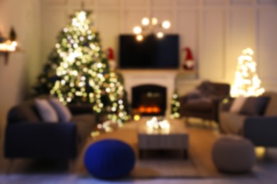 Blurred view of room with beautiful Christmas tree near fireplace