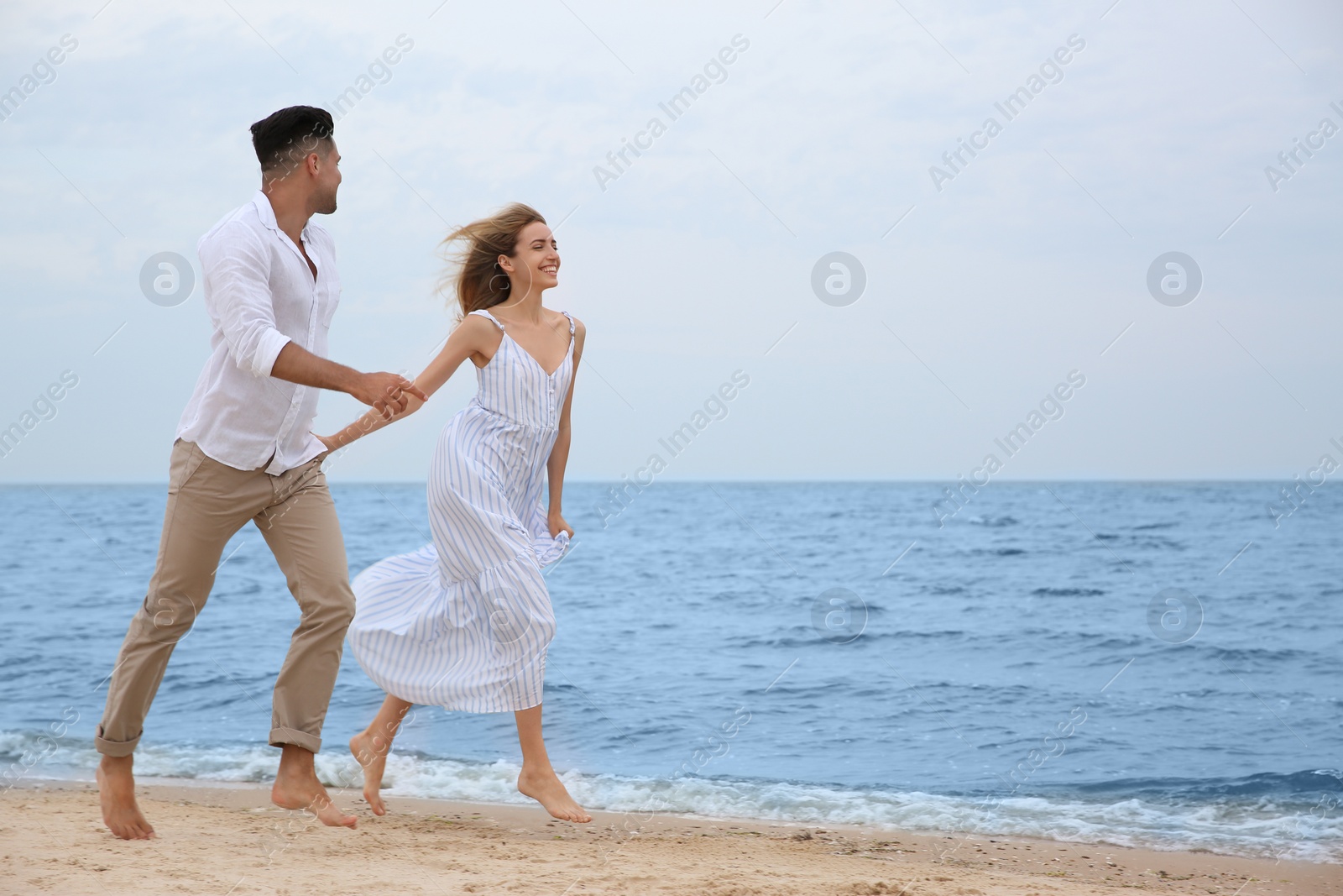 Photo of Happy couple running on beach, space for text. Romantic walk