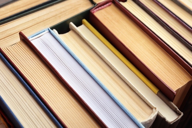 Many different hardcover books as background, closeup