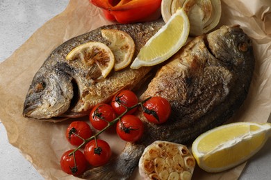 Photo of Delicious dorado fish with vegetables served on table, closeup