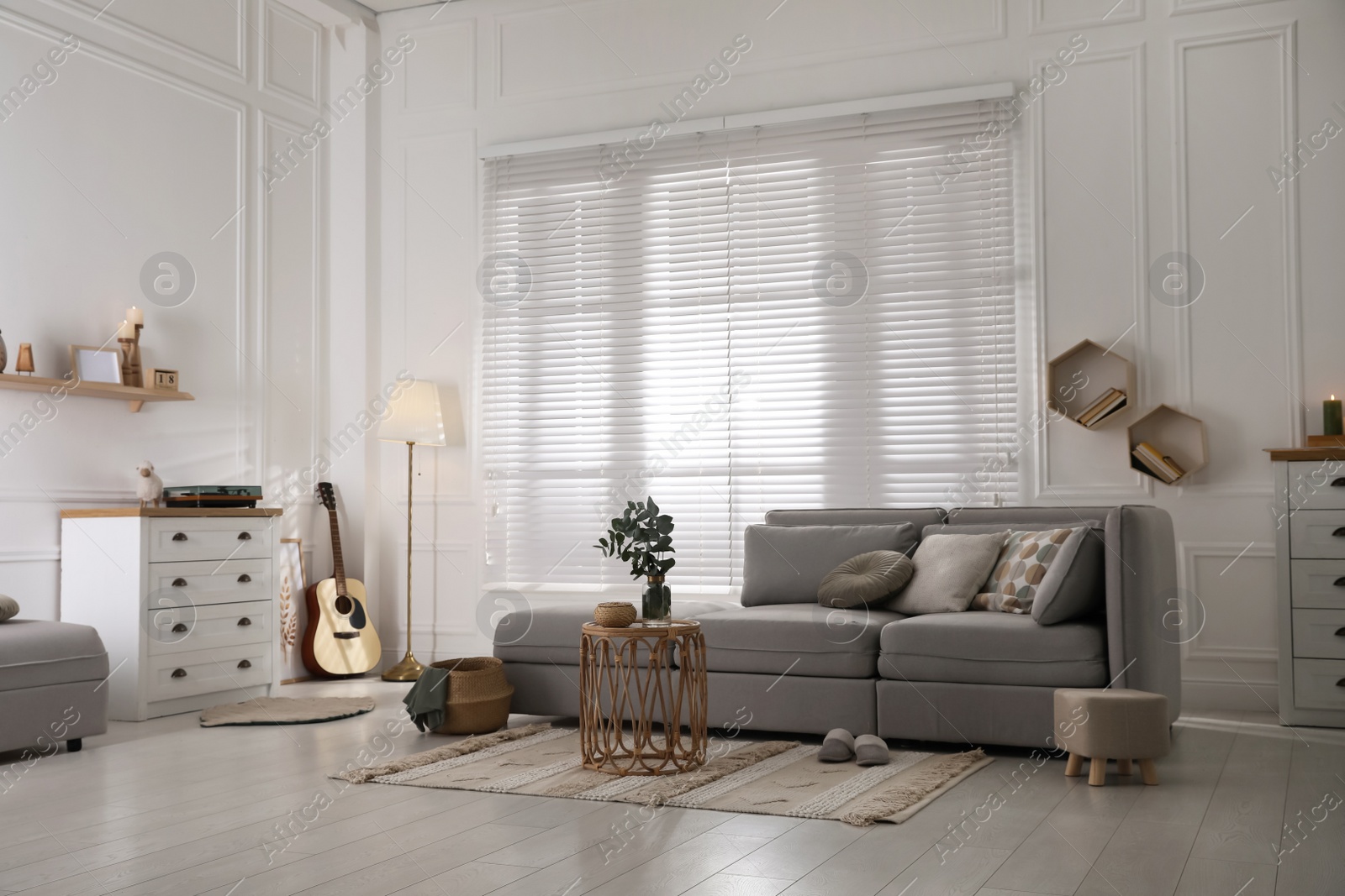 Photo of Living room with comfortable grey sofa and stylish interior elements near window