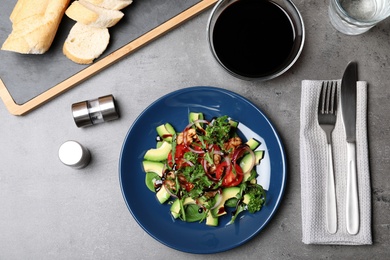 Photo of Vegetable salad served with balsamic vinegar on grey table, top view