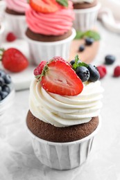 Photo of Sweet cupcake with fresh berries on light table
