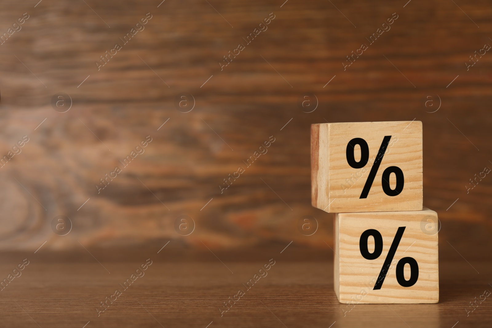 Photo of Wooden cubes with percent signs on table, space for text