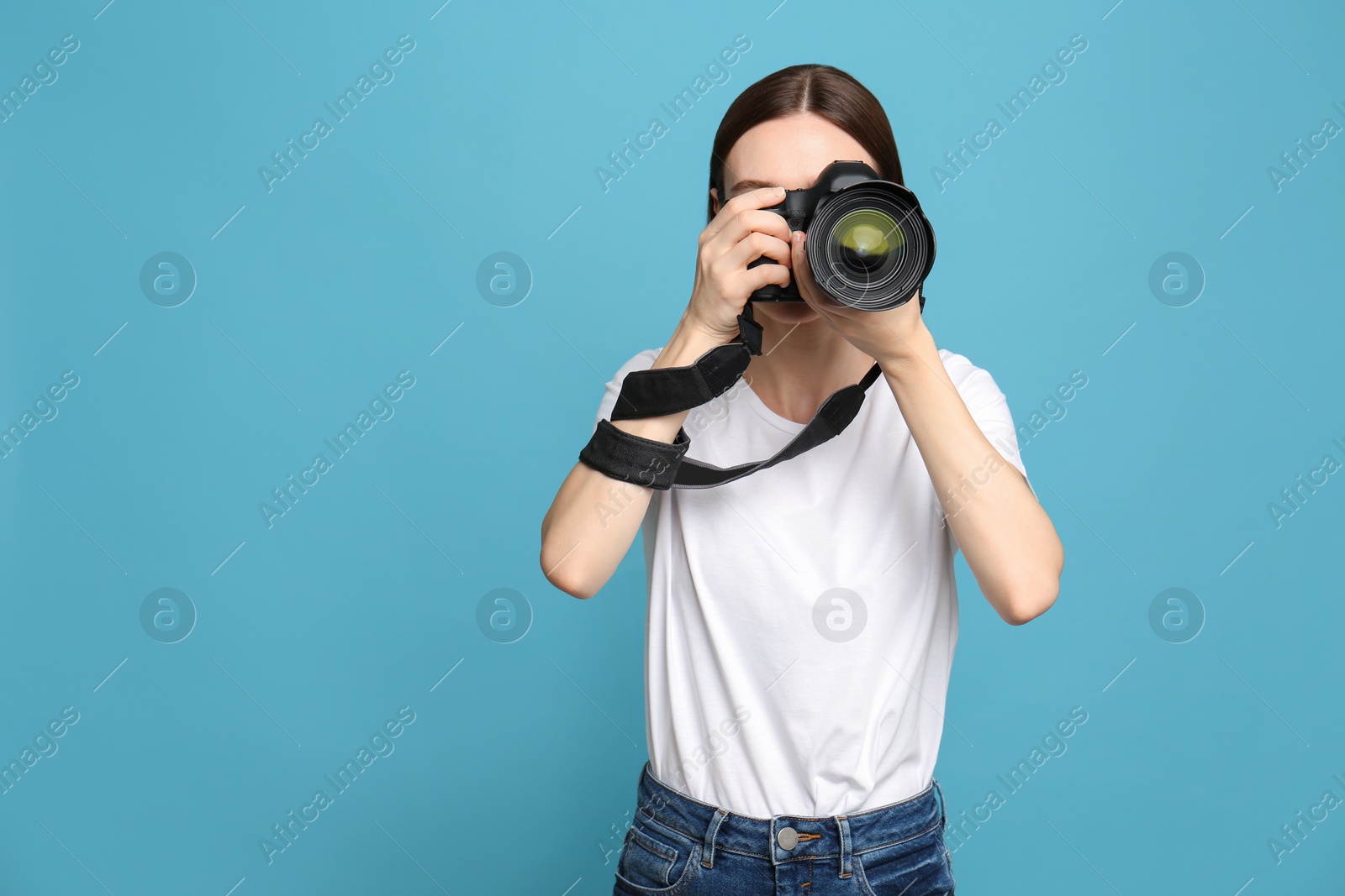 Photo of Professional photographer taking picture on light blue background