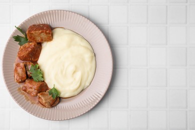 Photo of Delicious goulash with mashed potato on white tiled table, top view. Space for text