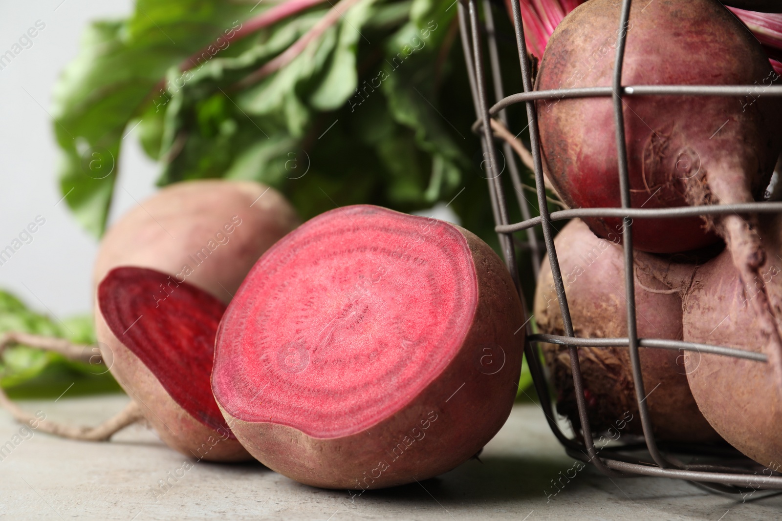 Photo of Cut fresh ripe beets on light grey table, closeup