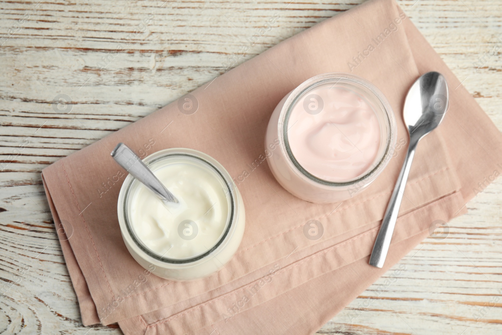 Photo of Tasty organic yogurt on white wooden table, top view