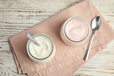 Tasty organic yogurt on white wooden table, top view