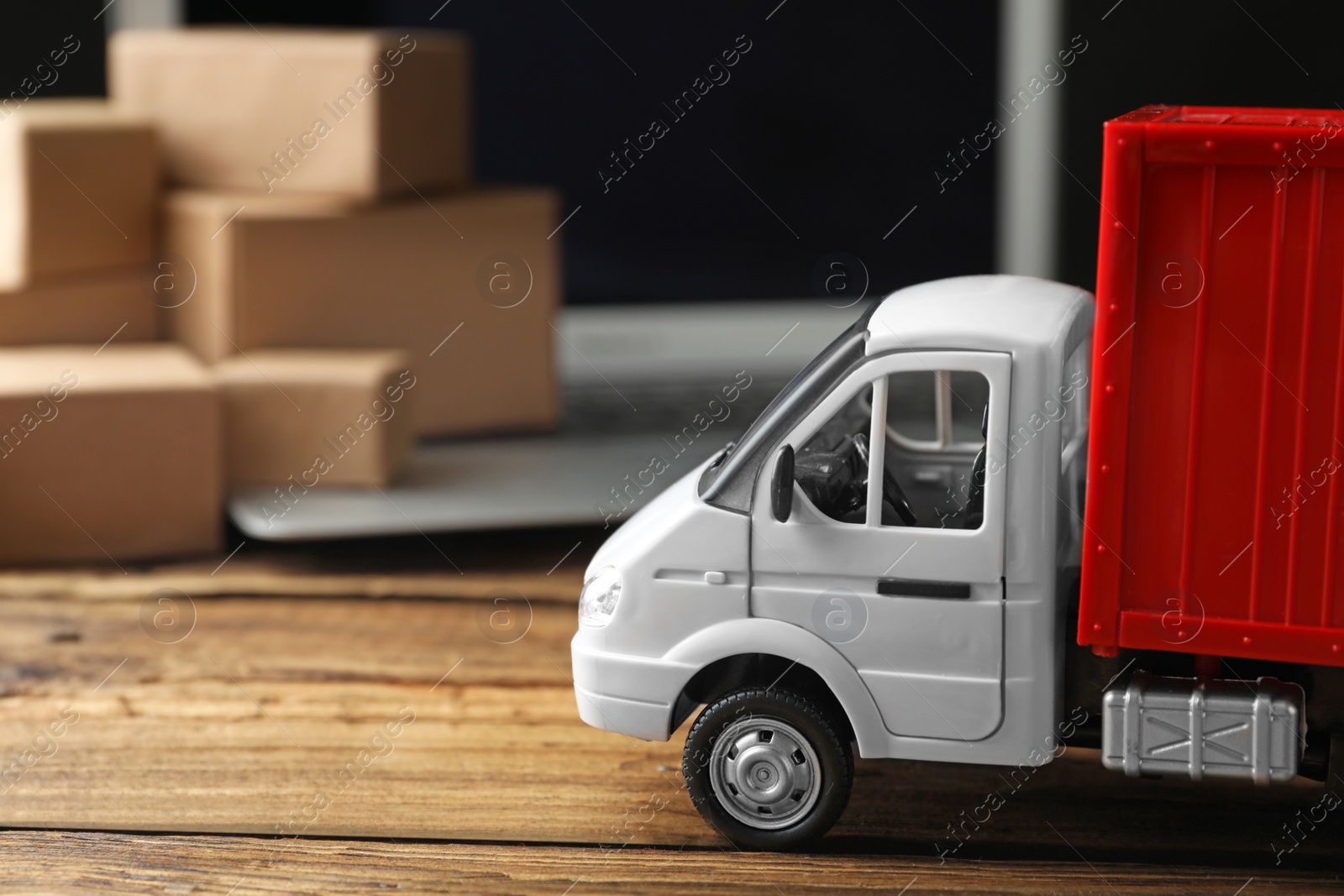 Photo of Toy truck on wooden table. Logistics and wholesale concept