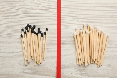 Photo of Flat lay composition with different matches on white wooden background. Racism concept