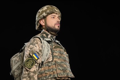 Photo of Soldier in Ukrainian military uniform with backpack on black background