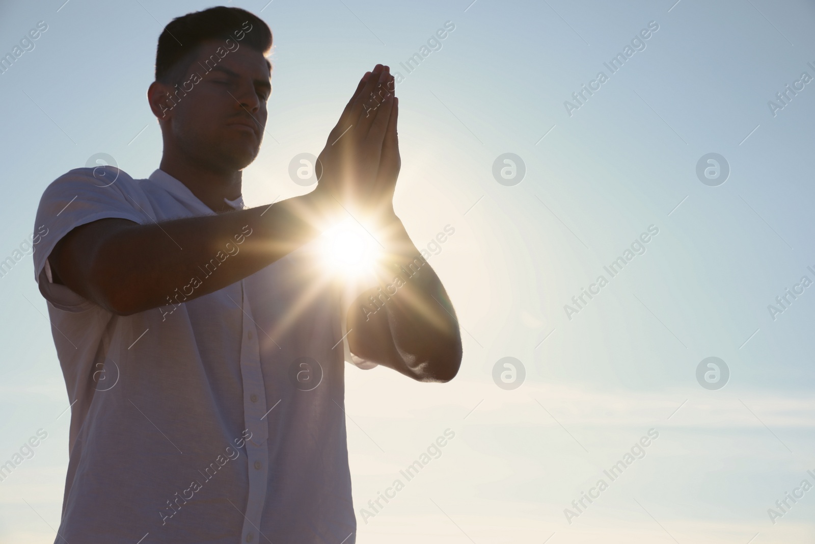 Photo of Man meditating against blue sky, space for text. Nature healing power